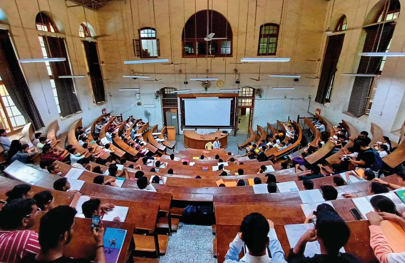 The hall featured in Munna Bhai MBBS, known for its grand architecture with spiral staircases and teakwood benches, is the Anatomy Lecture Hall at Grant Government Medical College, often referred to as the “Munna Bhai MBBS Auditorium” by students and fans